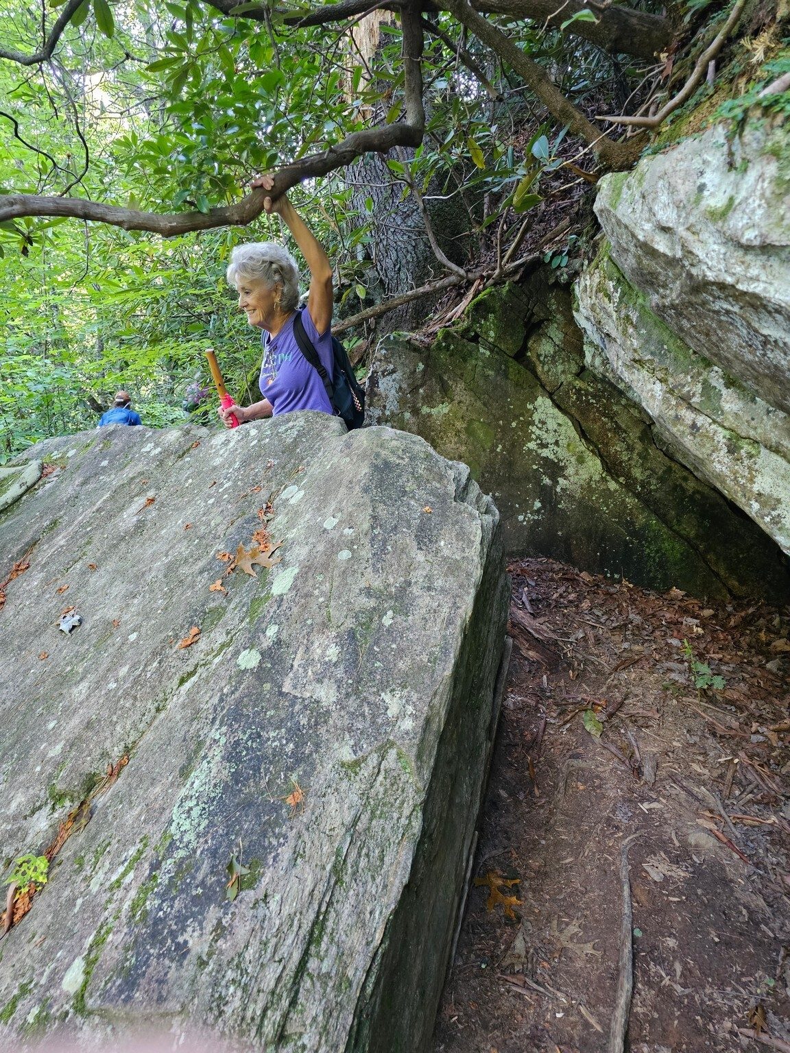 Beth squeezing through a boulder gauntlet in the trail.