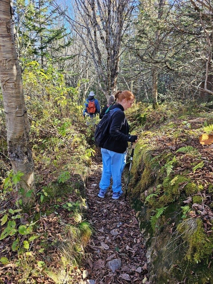 Jane checking out something as we progress along  a rocky "trench," aka trail, toward Sam Knob.